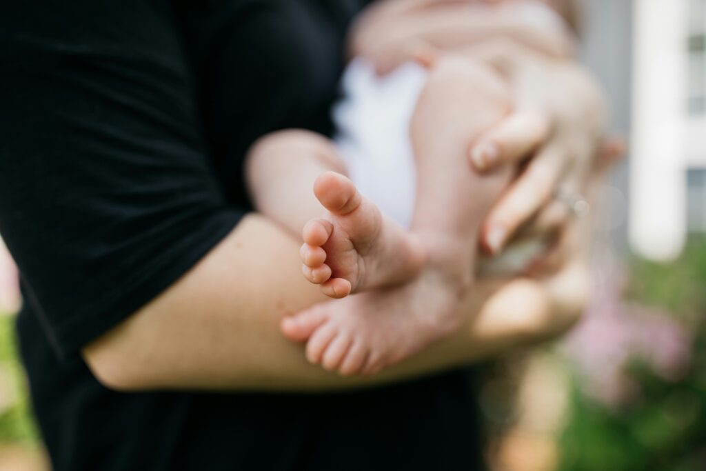 The picture shows a parent holding a young child in their arms